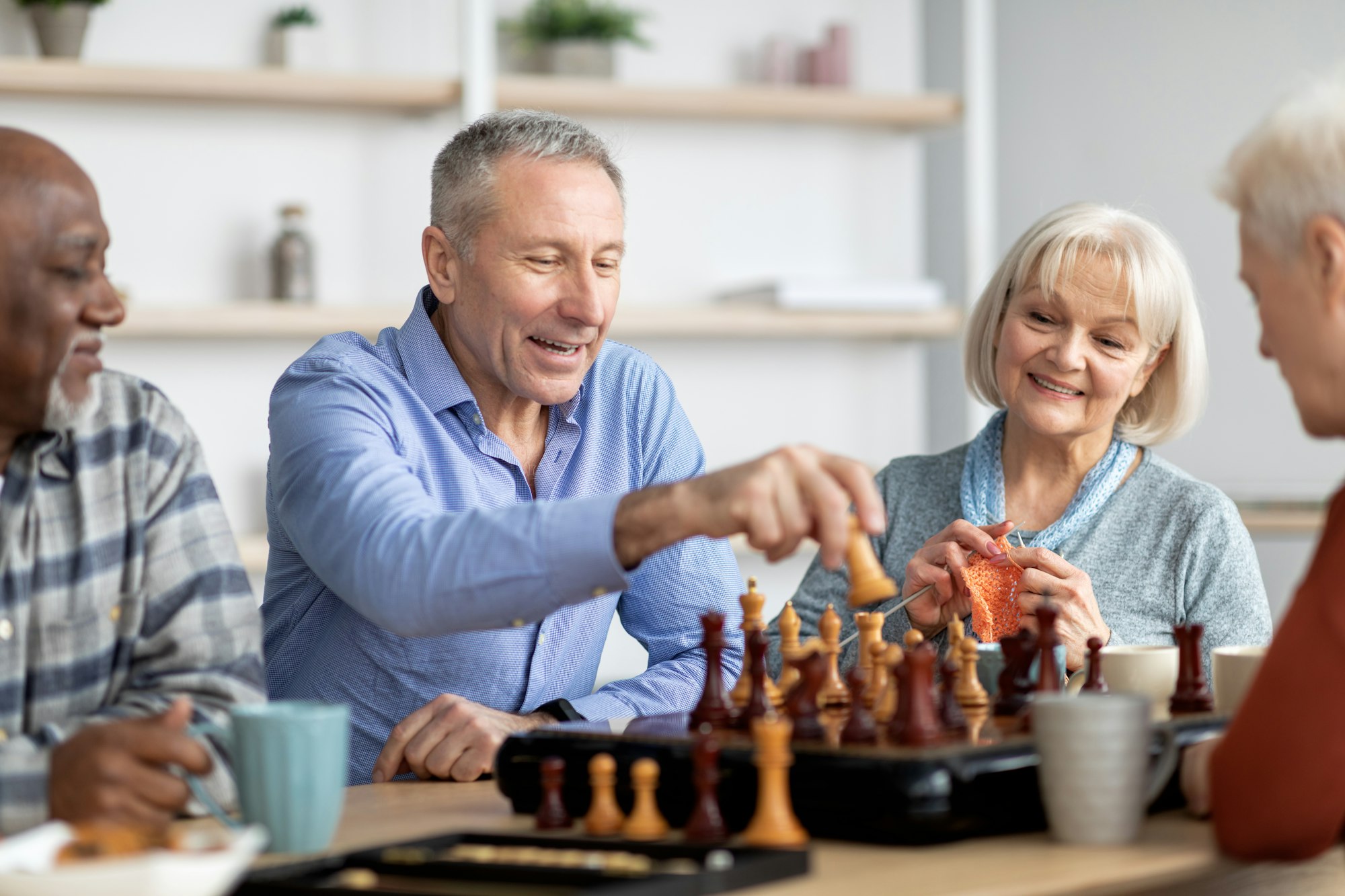 Happy elderly people playing table games at nursing home