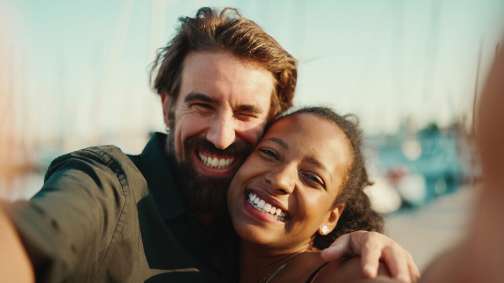 Close up portrait of happy man and smiling woman doing selfie on smartphone