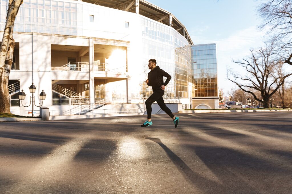 Portrait of young sportsman in earphones jogging